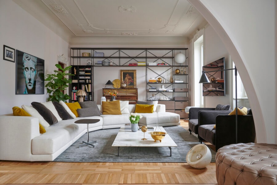 Divano Alberese, tavolino Flying Landscape, poltrone Blendy Lounge e libreria R.I.G. di De Padova arredano il living.