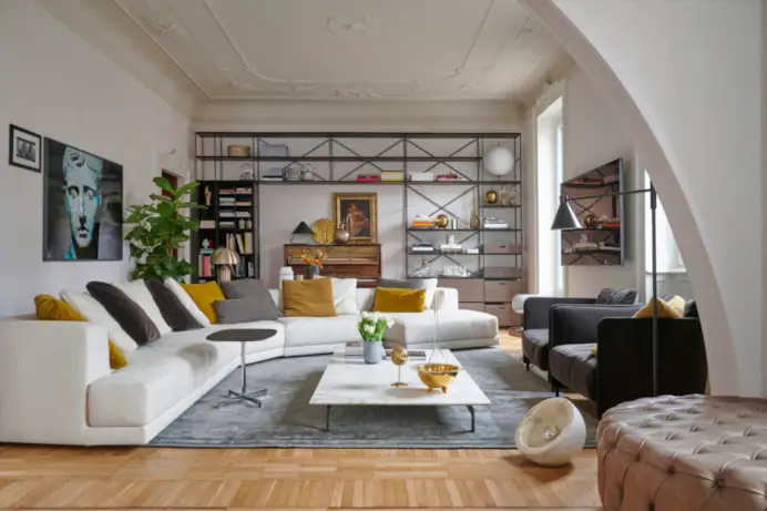 Divano Alberese, tavolino Flying Landscape, poltrone Blendy Lounge e libreria R.I.G. di De Padova arredano il living.