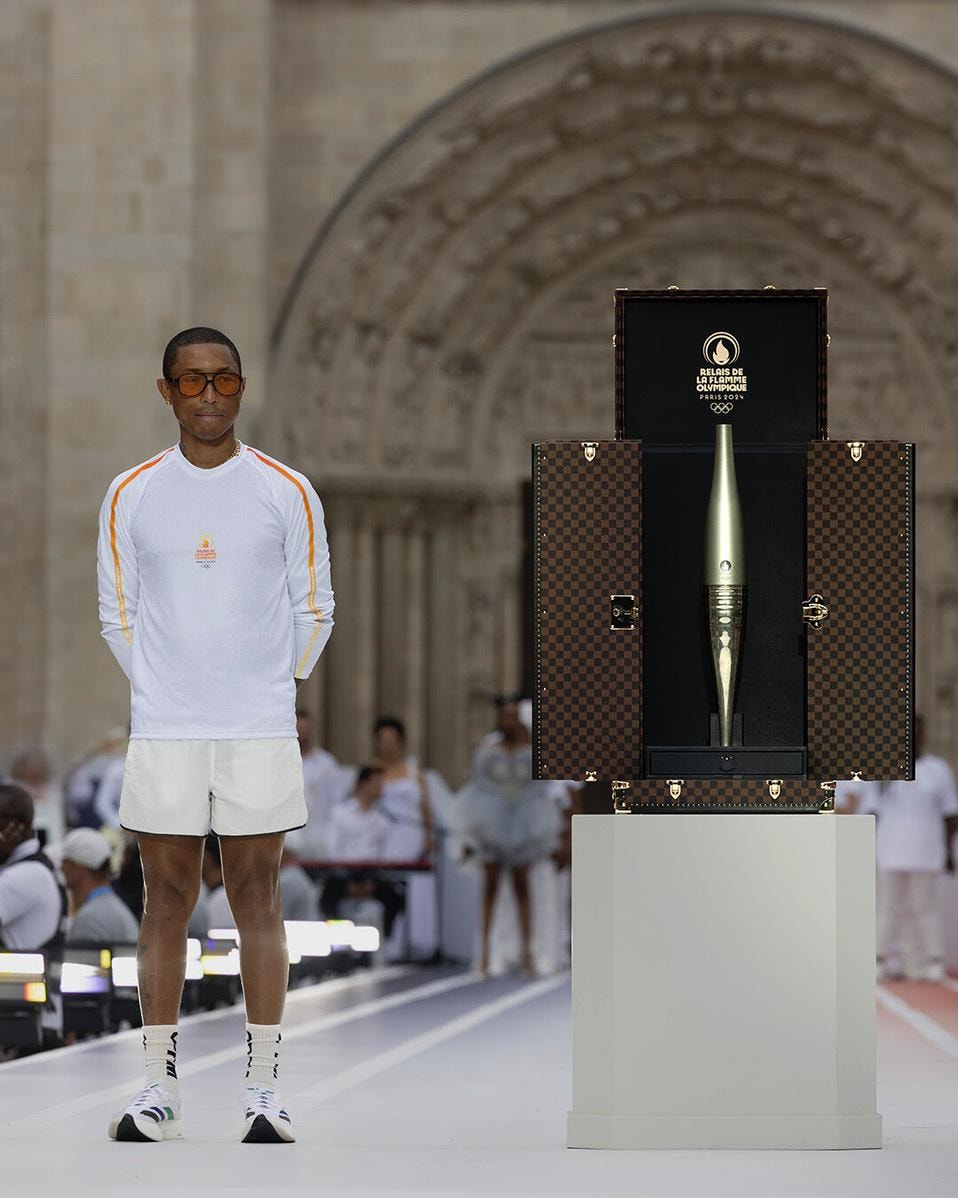 Pharrell Williams con la fiamma olimpica custodita all’interno di un baule Louis Vuitton (courtesy Louis Vuitton)
