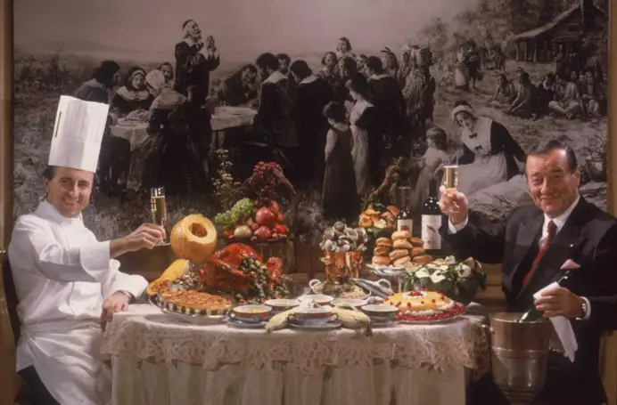 Il brindisi tra Sirio Maccioni, fondatore del gruppo di ristorazione Le Cirque, capace di incantare con i sapori italiani il jet set di New York e mondiale, e lo chef francese Daniel Boulud, ritratto da Slim Aarons nel 1990.