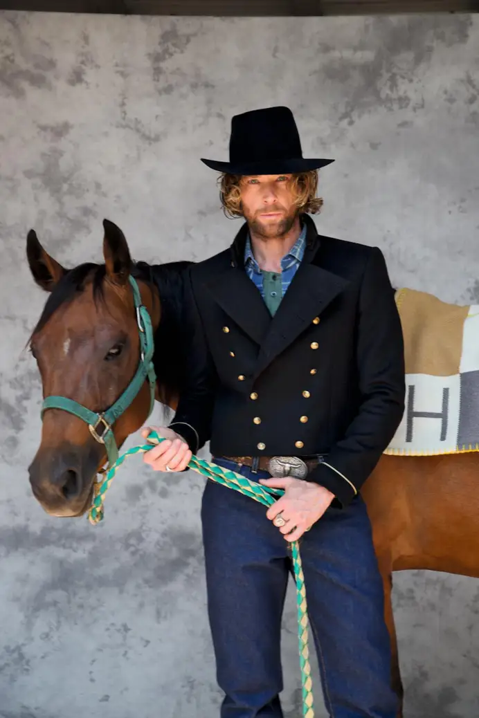Bolero in panno con bottoni in metallo e cappello, tutto di Emporio Armani; camicia texana, Giannetto Portofino; serafino in cotone, Ovs; jeans, Levi’s; cintura western, Vintage; coperta di cashmere, Hermès.