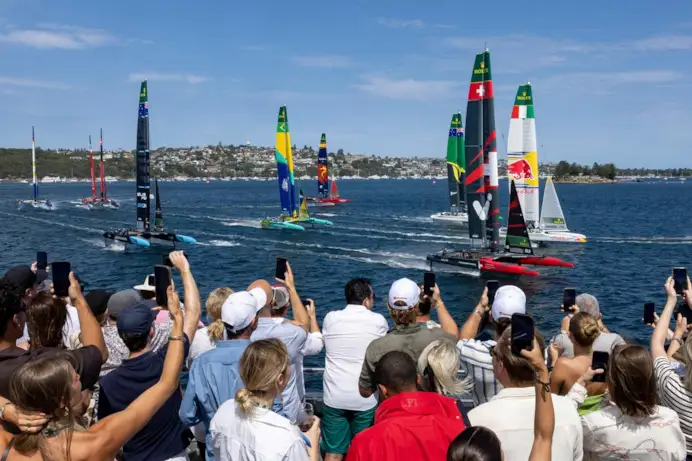 Gli spettatori assistono alla gara serrata a bordo dello yacht Adrenaline mentre il team svizzero SailGP guidato da Sebastien Schneiter conduce la flotta davanti al team italiano Red Bull SailGP durante il primo giorno di gara del KPMG Australia Sail Grand Prix a Sydney, in Australia.