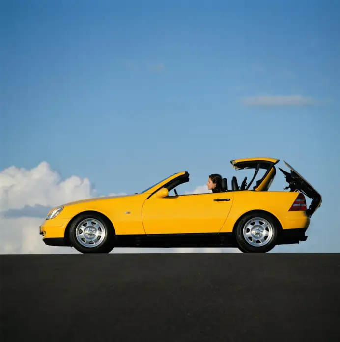 Mercedes-Benz SLK 200 der Baureihe R 170. Exterieurfoto von links mit sich öffnendem Variodach. (Fotosignatur der Mercedes-Benz Classic Archive: A96F1282)
Mercedes-Benz SLK 200 in model series R 170. Exterior photo from left with the folding vario-roof opening. (Photo signature in the Mercedes-Benz Classic archive: A96F1282)