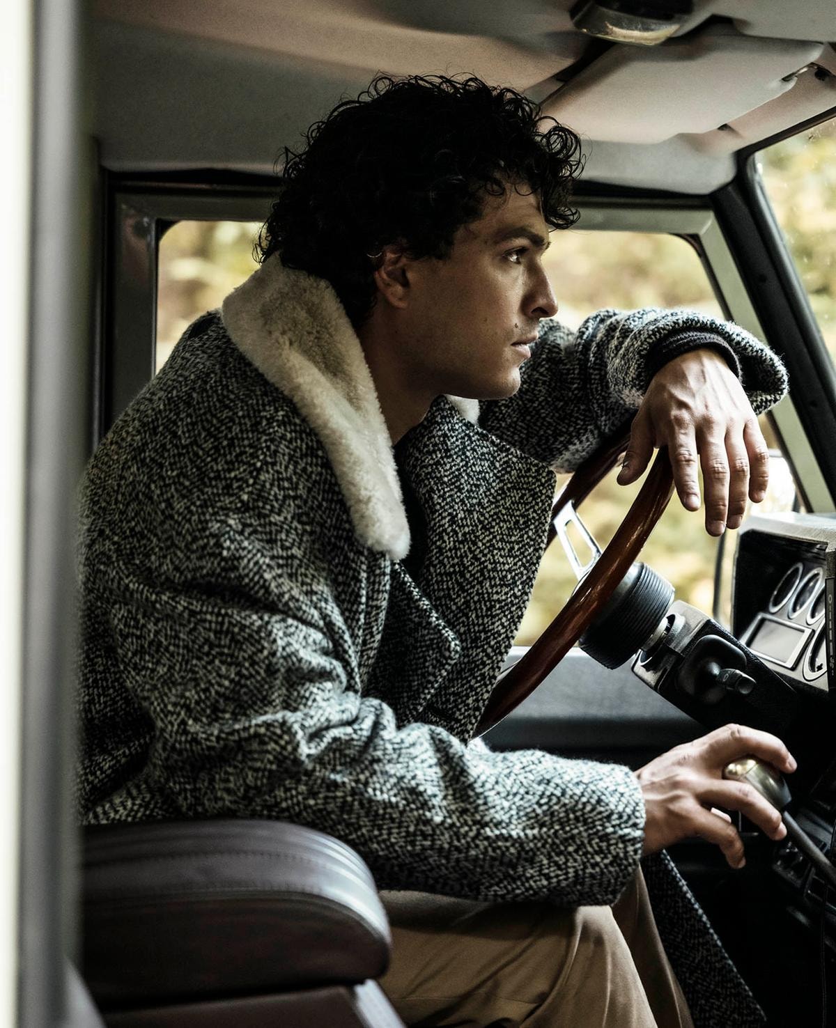 Cappotto doppiopetto in cashmere e lana con collo in shearling, maglione scollo a V in cashmere, pantaloni in lana, tutto di Zegna.