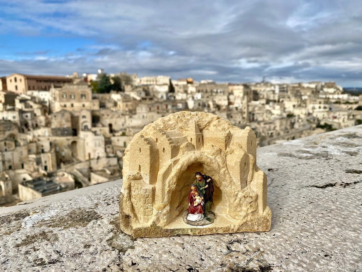 Piccolo presepe su pietra di Matera con sfondo su città di Matera
