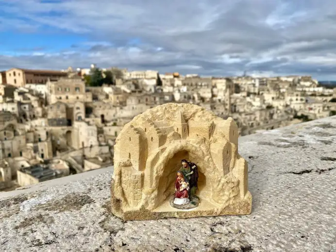 Piccolo presepe su pietra di Matera con sfondo su città di Matera