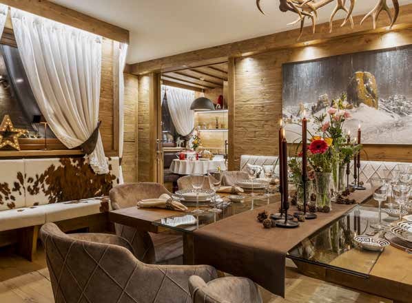 Il legno è il filo conduttore di tutto  il progetto della casa nel centro storico  di Cortina, con zona living dal layout generoso.