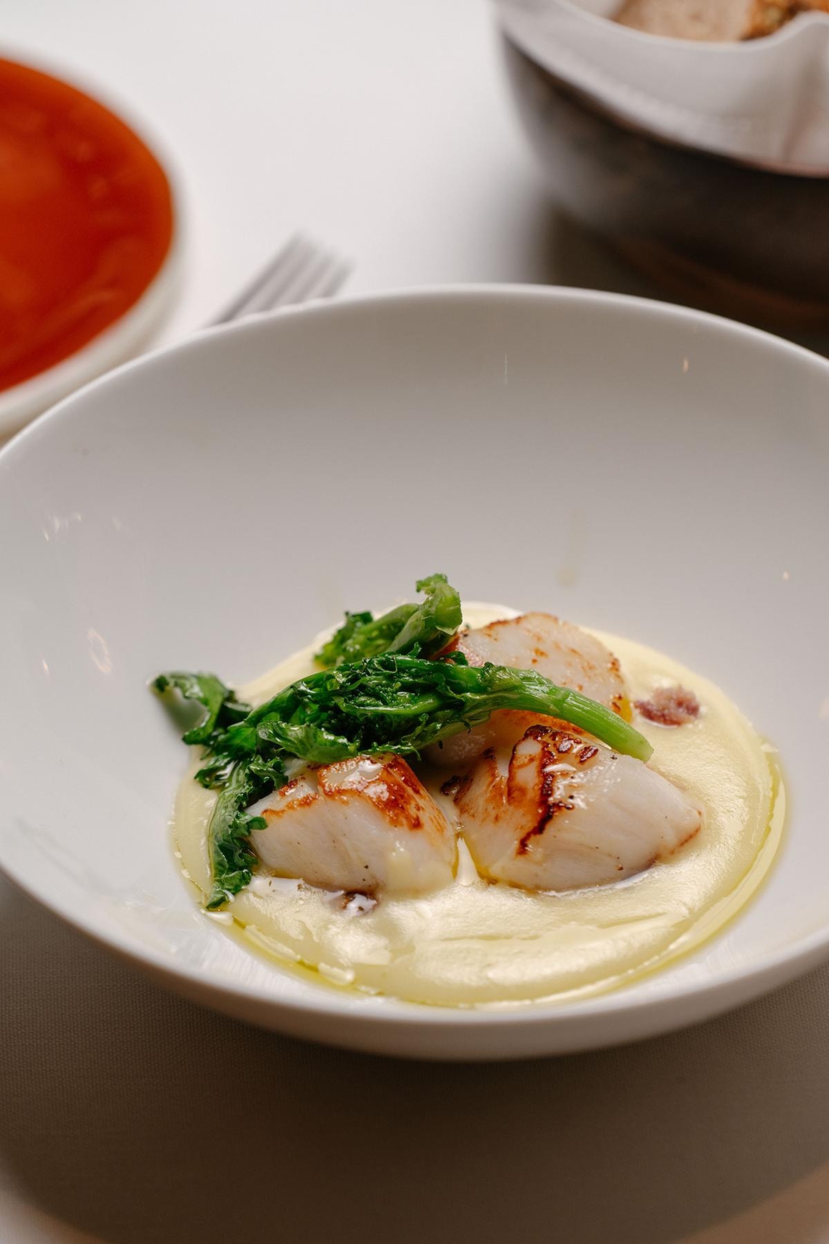 Capesante con crema di patate, cotechino e cime di rapa