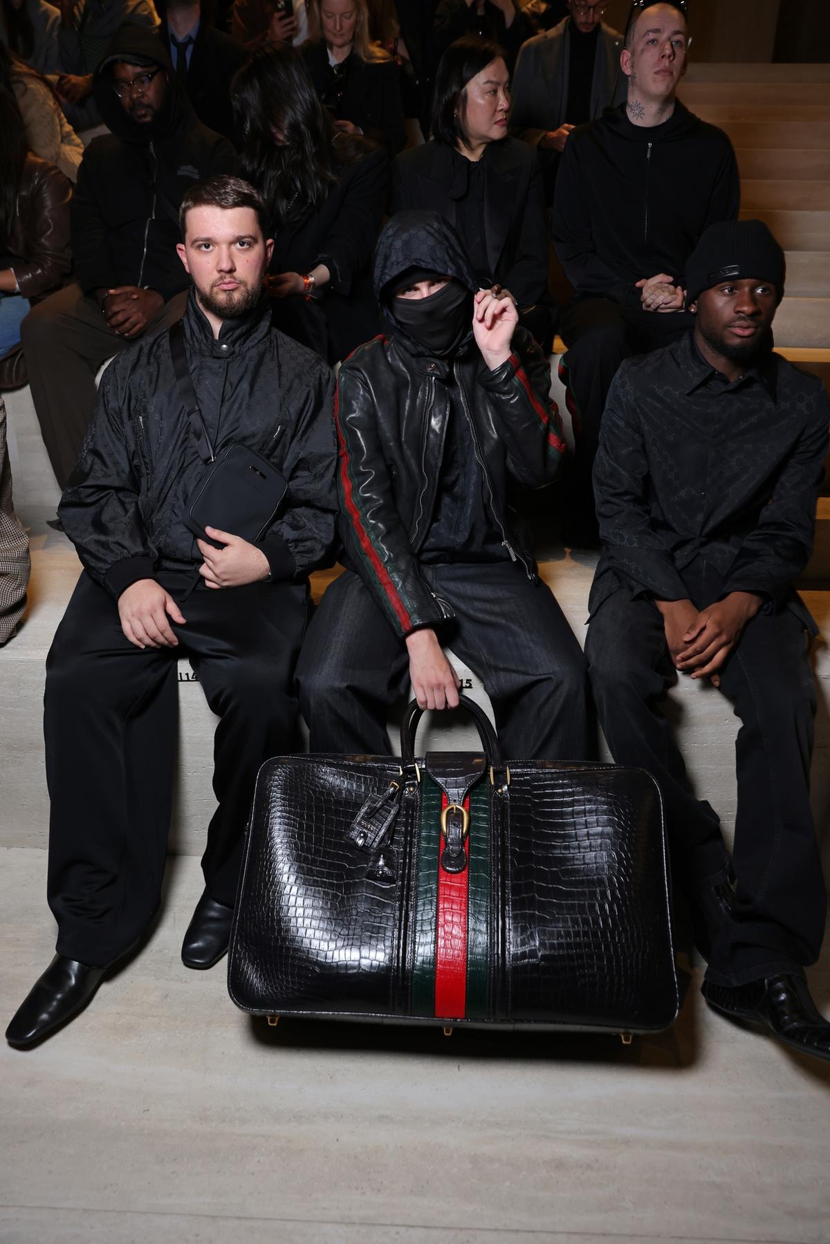 Al centro, con il volto coperto, EsDeeKid in front row Gucci fall-winter 2026/27 (courtesy Gucci)