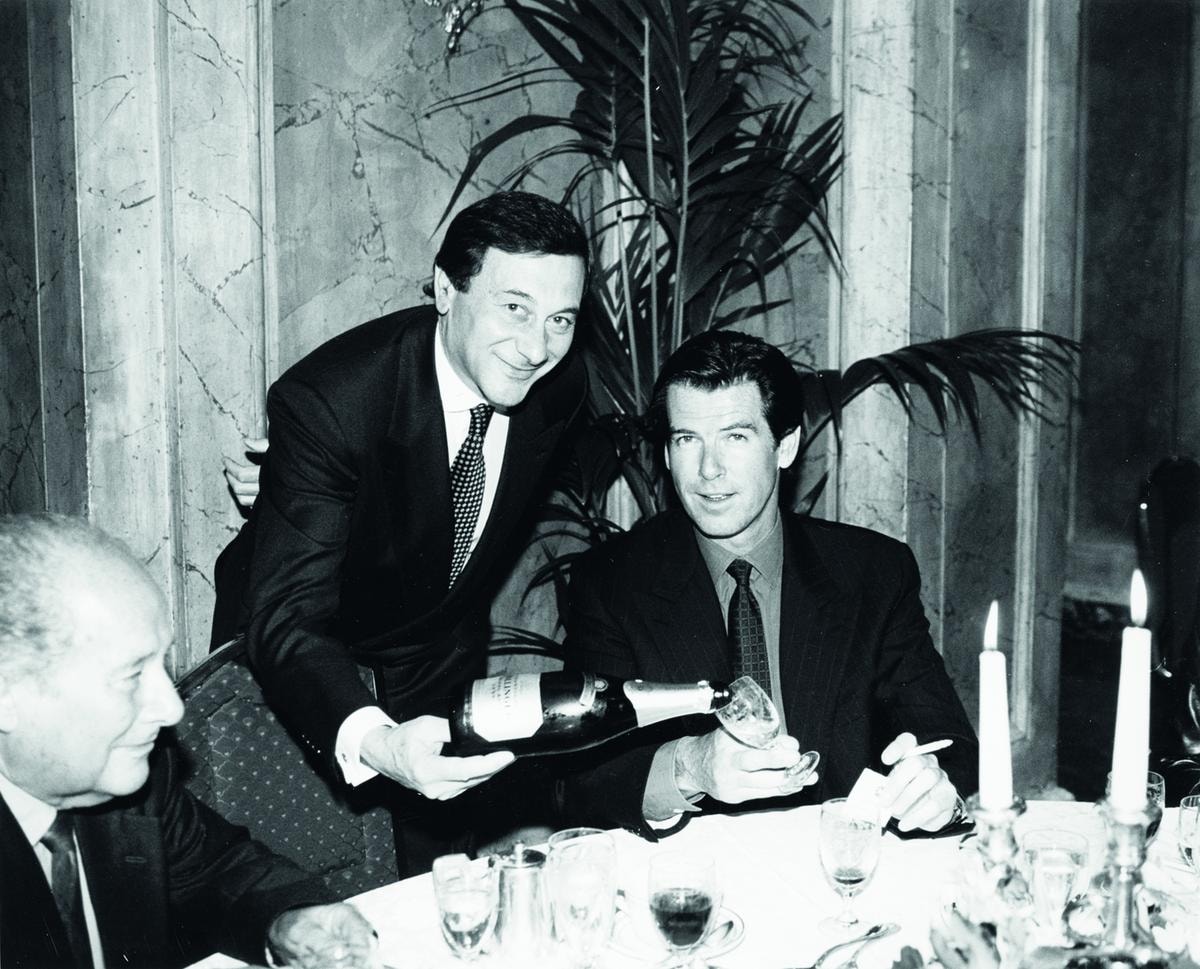 Giuseppe Meregalli versa dello champagne Bollinger all'attore Pierce Brosnan allora volto di 007.
