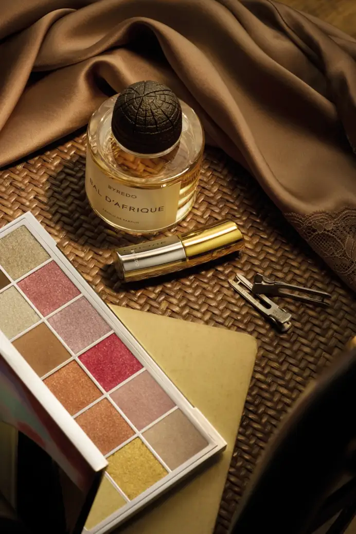 Dall’alto, Bal d’Afrique absolu de parfum, balsamo labbra nella nuance Cloud busting e palette di ombretti Vesuvio con 18 colori, tutto di Byredo (ph Sonia Marin)