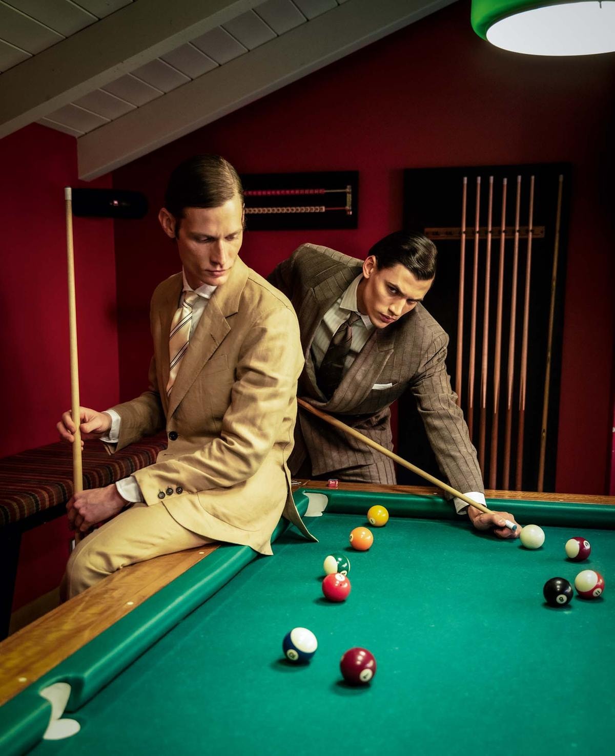 Seduto in primo piano, abito con giacca monopetto in lino, camicia in lino, tutto di Zegna; cravatta in seta, Brunello Cucinelli. In secondo piano, abito con giacca doppiopetto, camicia in cotone e cravatta in seta, tutto di Emporio Armani; pochette in cotone, Fumagalli 1891.