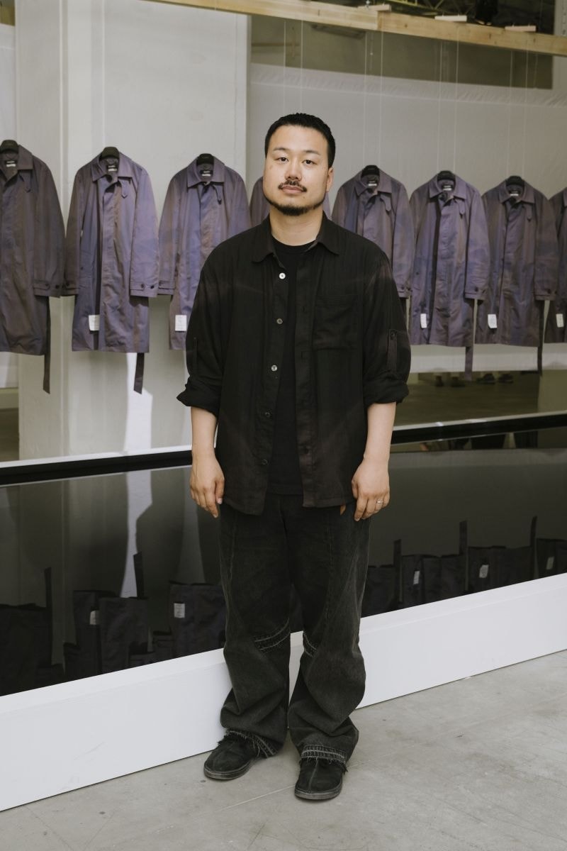 In esclusiva per MFF, Jiyong Kim di fronte all'installazione del suo brand a Pitti uomo 110 (ph Vanni Bassetti, courtesy Pitti immagine)