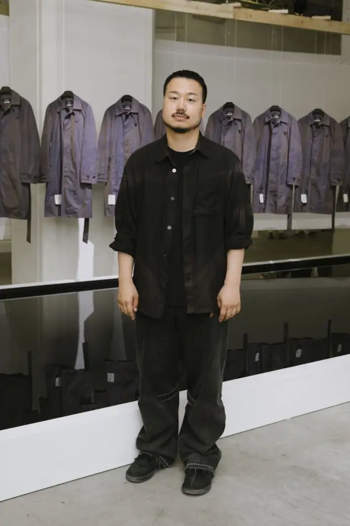 In esclusiva per MFF, Jiyong Kim di fronte all'installazione del suo brand a Pitti uomo 110 (ph Vanni Bassetti, courtesy Pitti immagine)