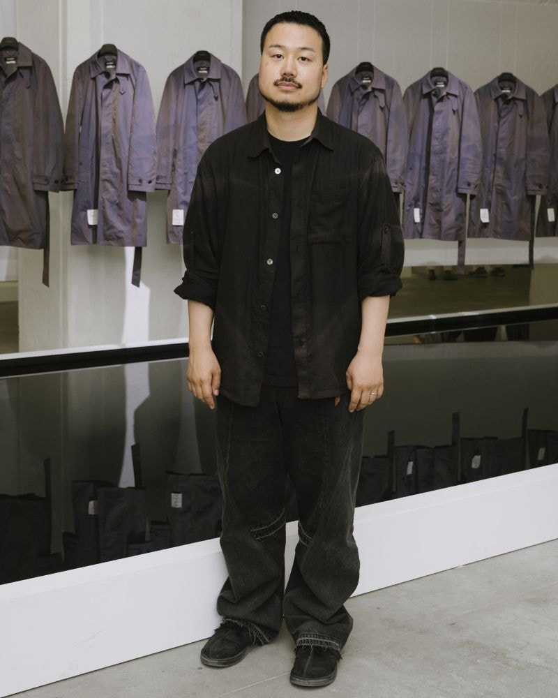In esclusiva per MFF, Jiyong Kim di fronte all'installazione del suo brand a Pitti uomo 110 (ph Vanni Bassetti, courtesy Pitti immagine)