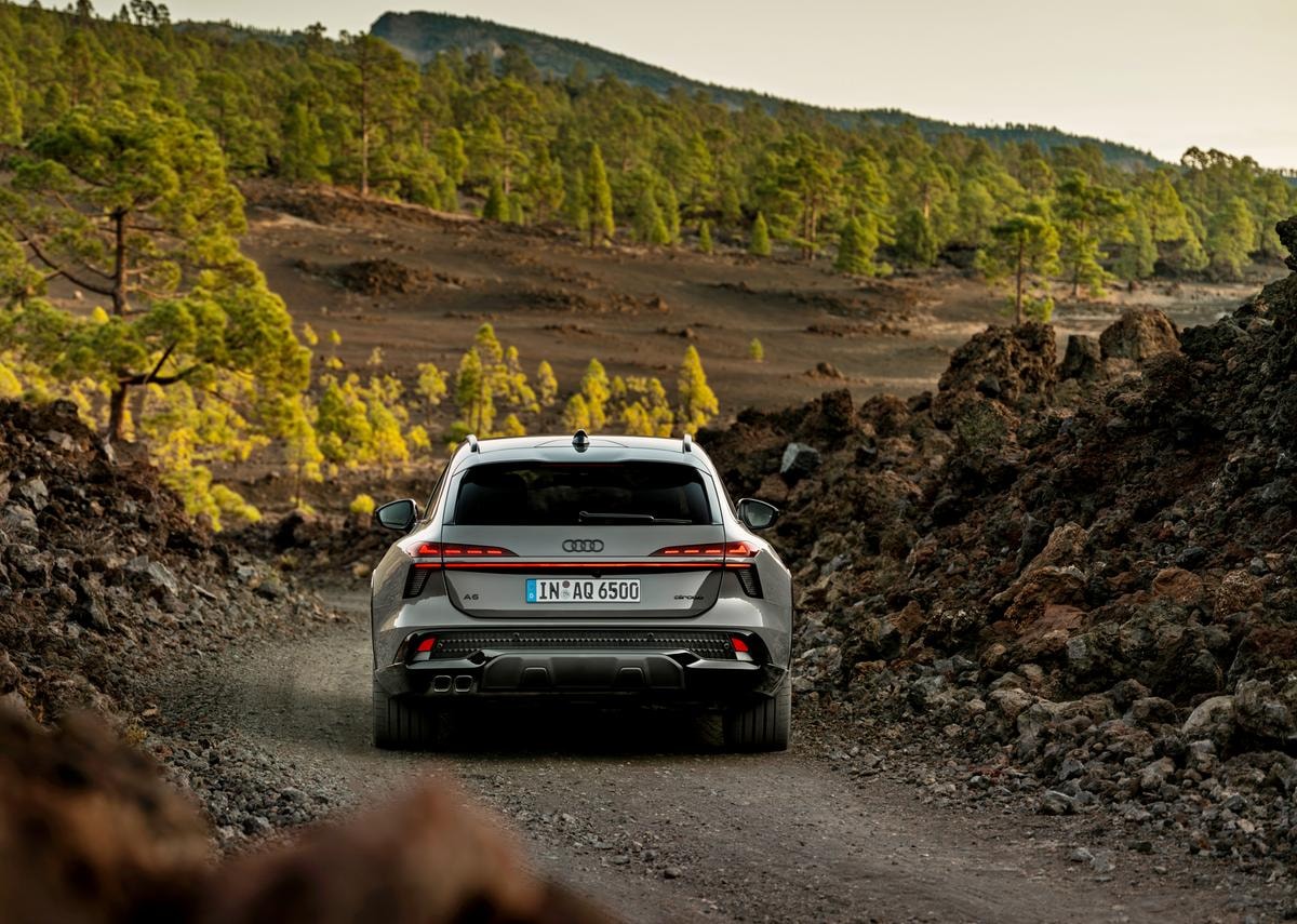 Rear view of the Audi A6 allroad (plateau grey metallic) on a narrow gravel track in volcanic terrain.